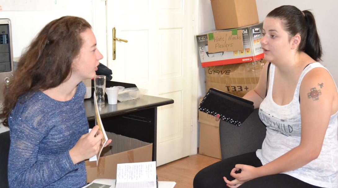Teenage volunteer chat with each other about different interview techniques during their Journalism Project Journalism volunteers practice their interviewing skills as part of their project in Romania